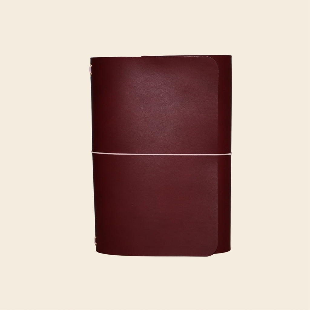 Maroon leather-bound book on a beige background