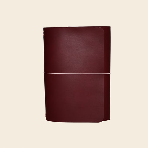 Maroon leather-bound book on a beige background
