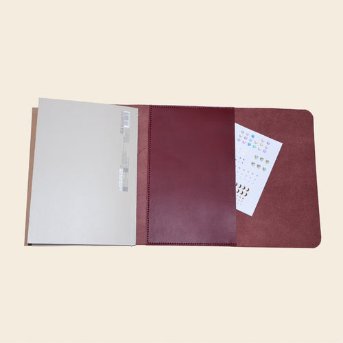 Brown leather journal with a pocket on a beige background