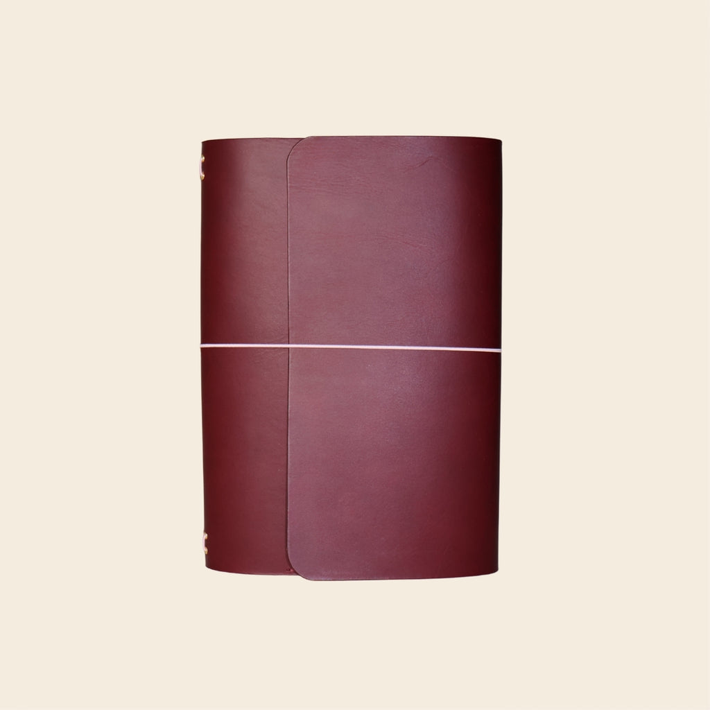 Maroon leather-bound book on a beige background