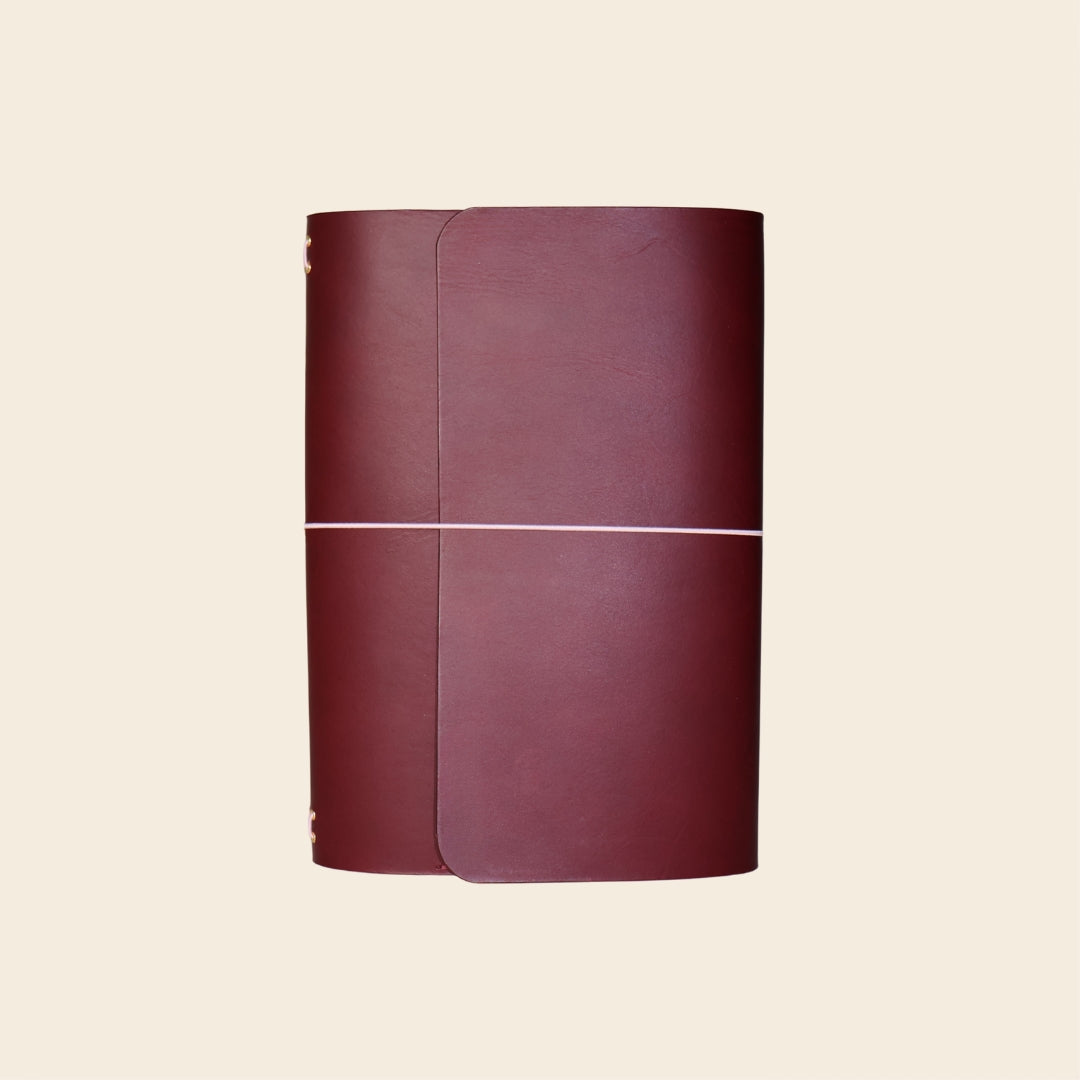 Maroon leather-bound book on a beige background