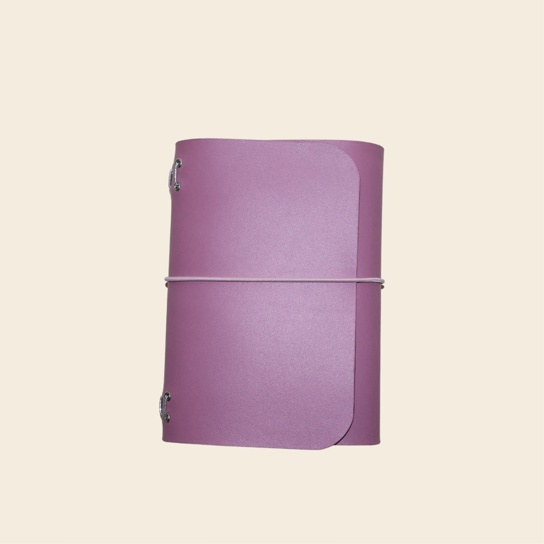 Purple notebook with a strap on a beige background