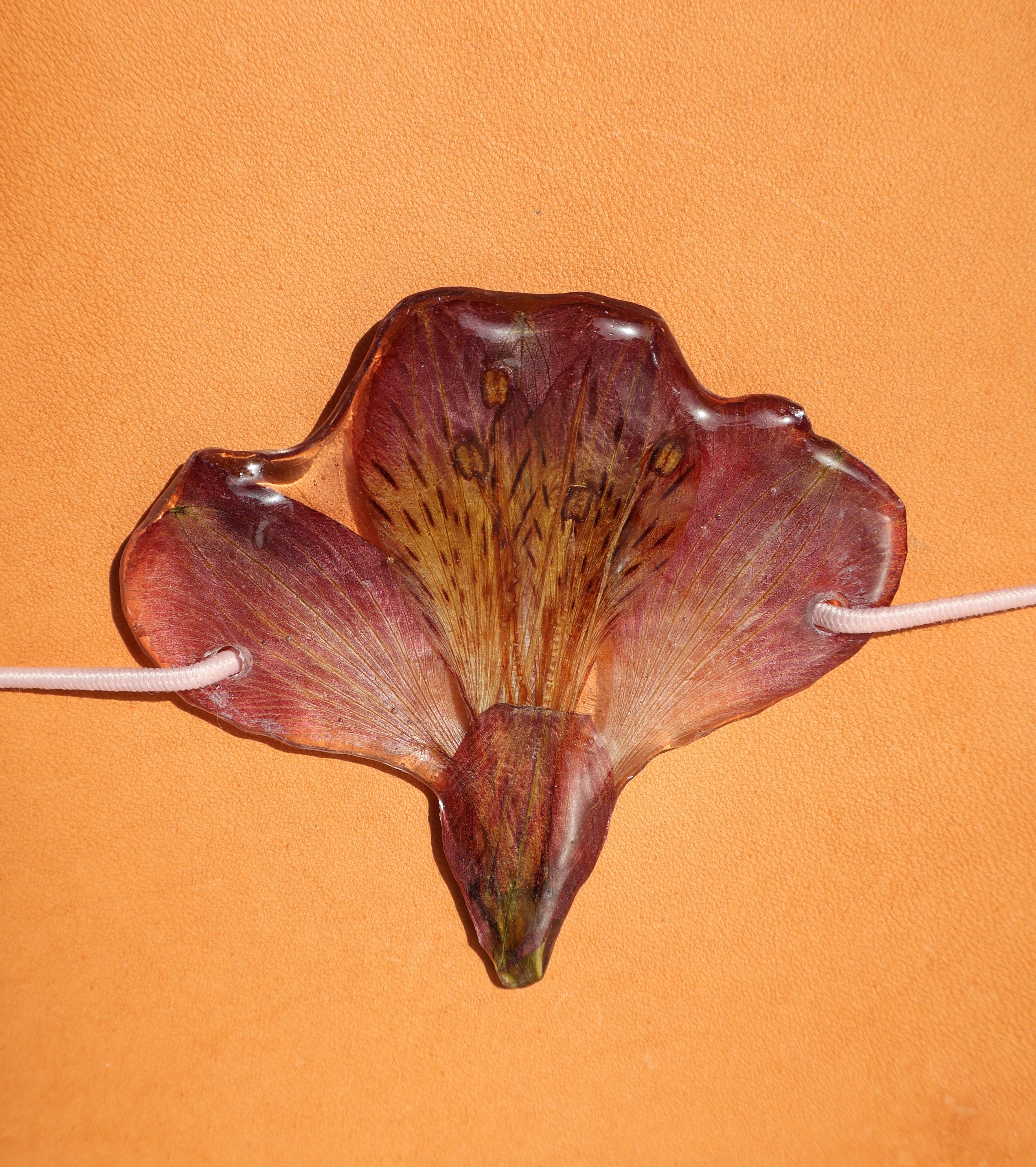 Artificial flower on a stick against an orange background