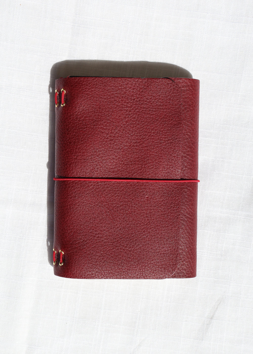 Red leather wallet with gold accents on a white background