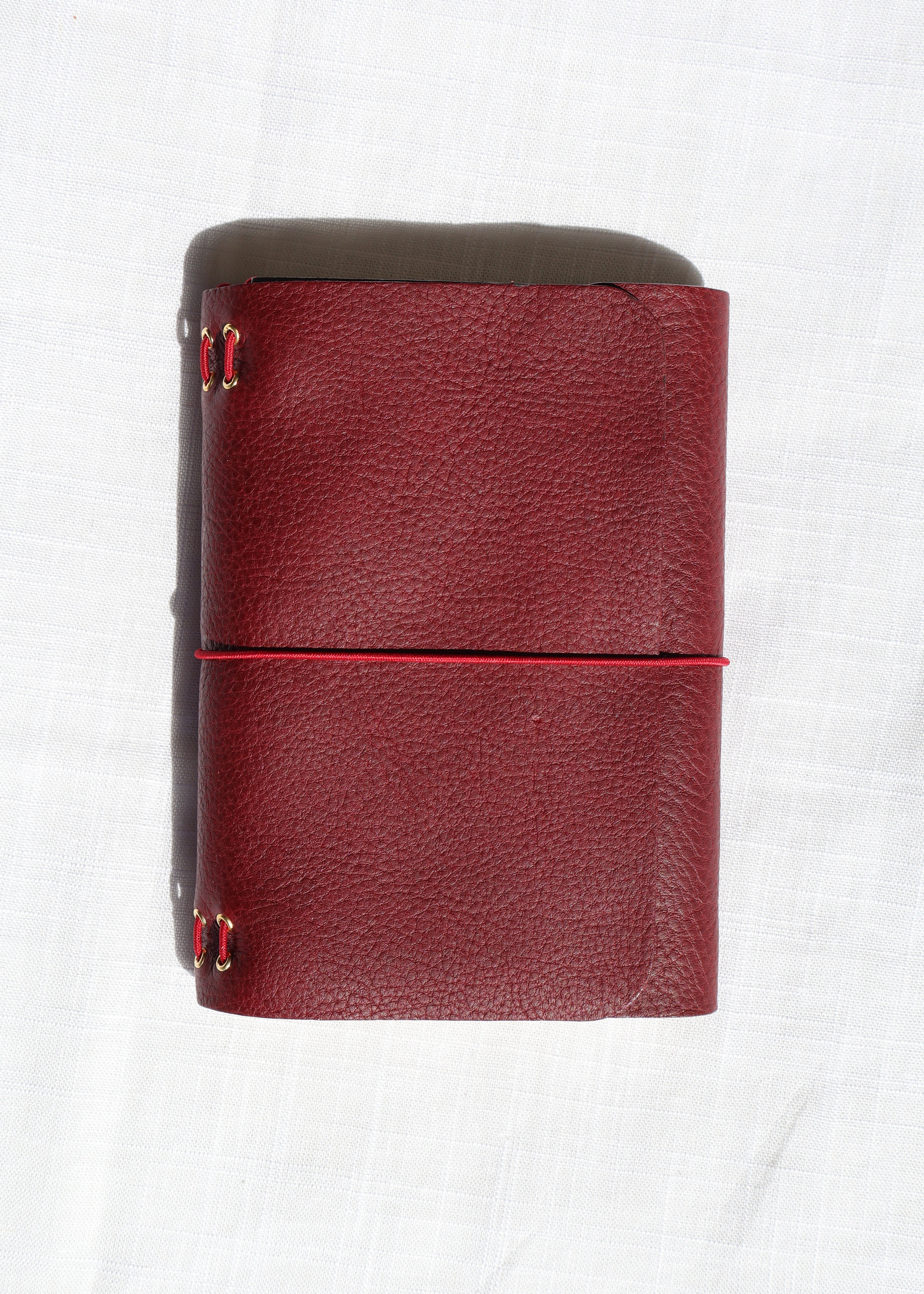 Red leather wallet with gold accents on a white background