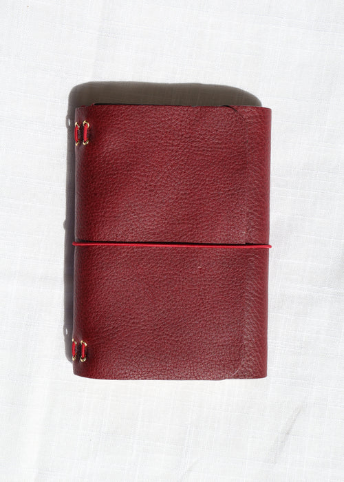 Red leather wallet with gold accents on a white background