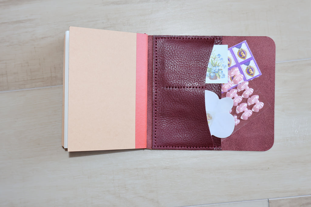 Open passport holder with cards and money on a wooden surface