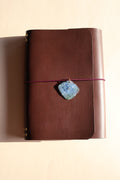 Brown leather with a decorative stone on a beige background
