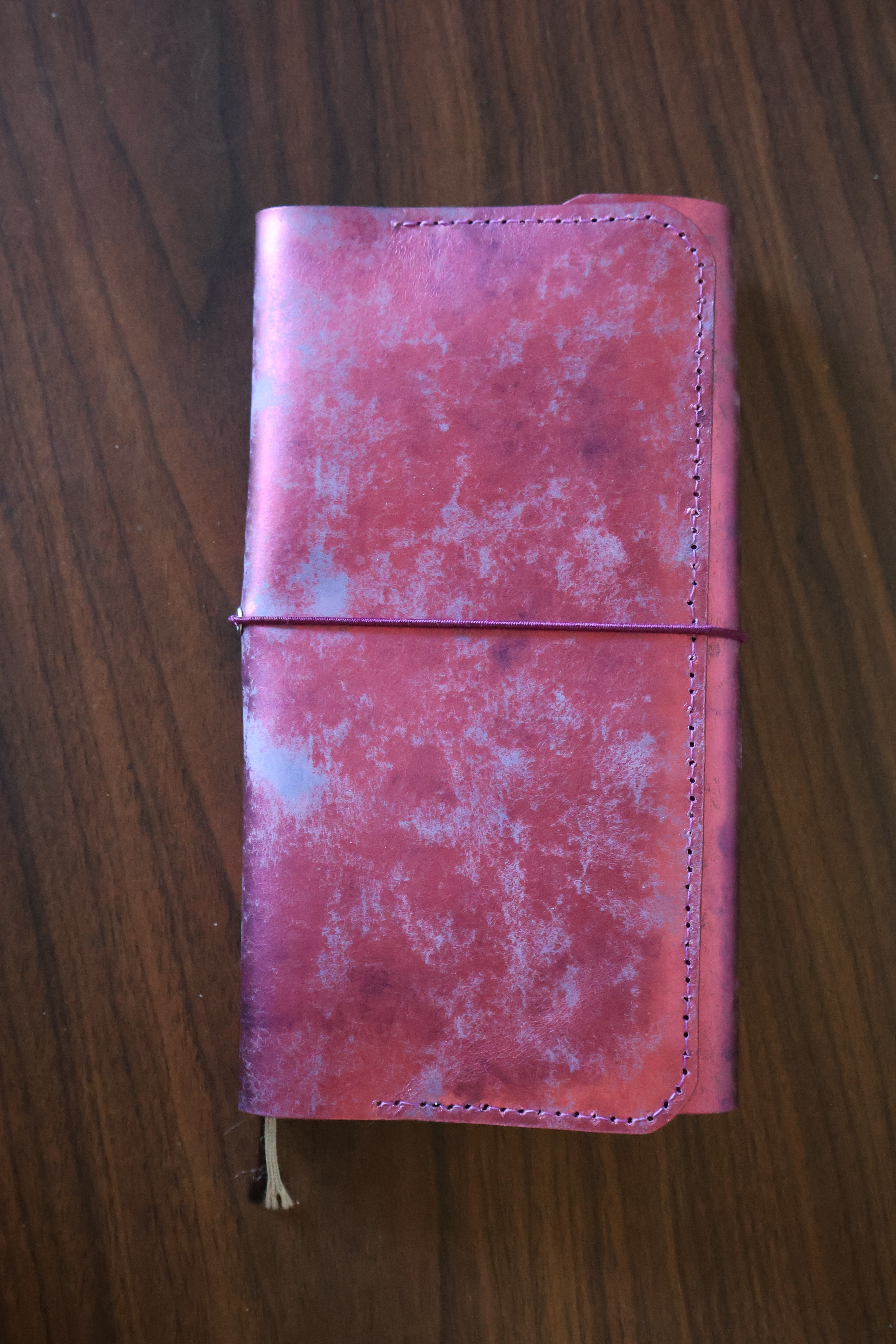 Pink leather wallet on a wooden surface