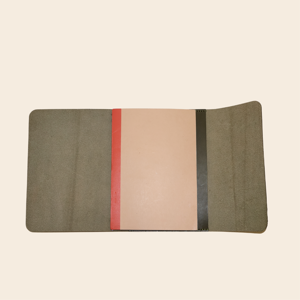 Open olive journal with a notebook on a beige background