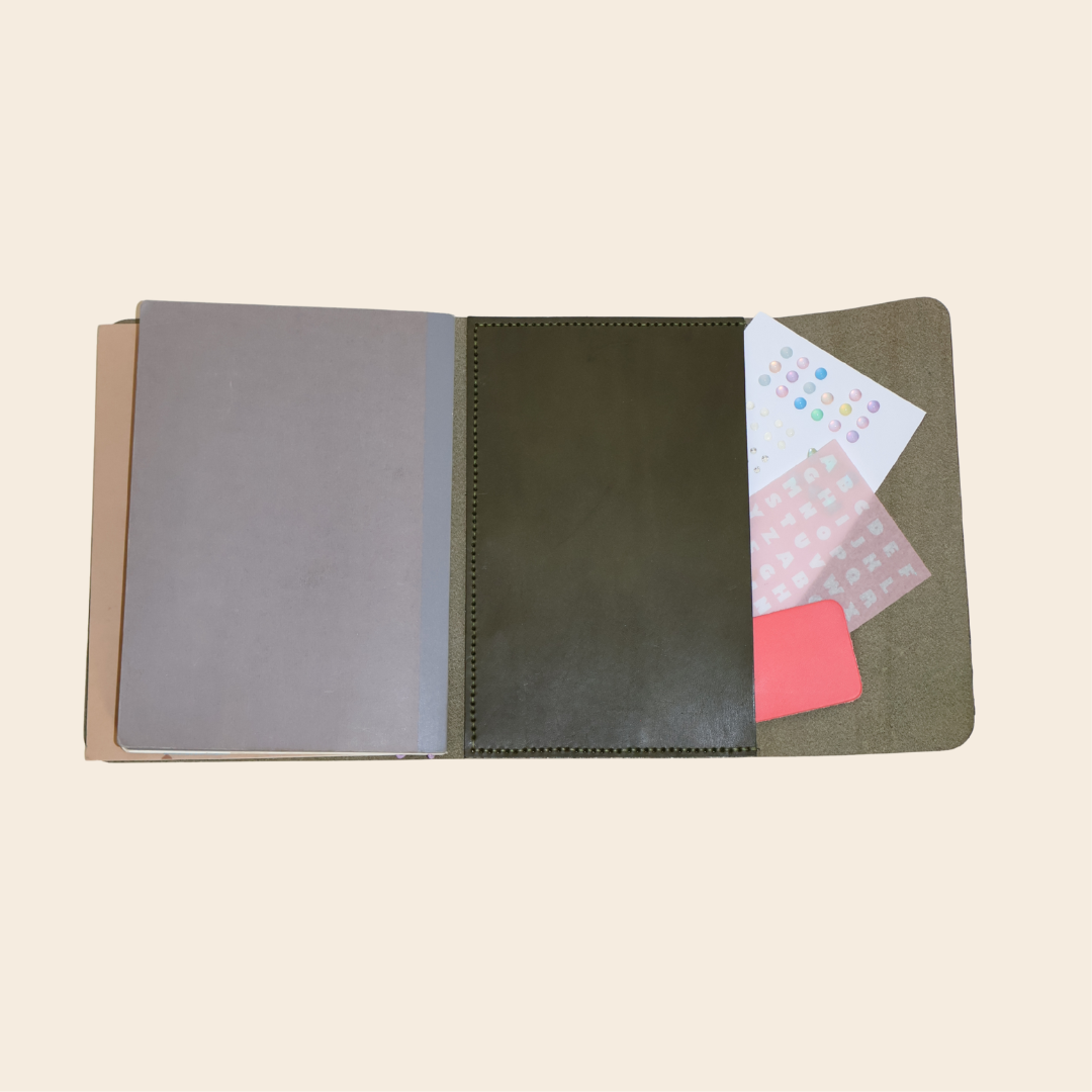 Open notebook with different colored pages in back pocket on a beige background