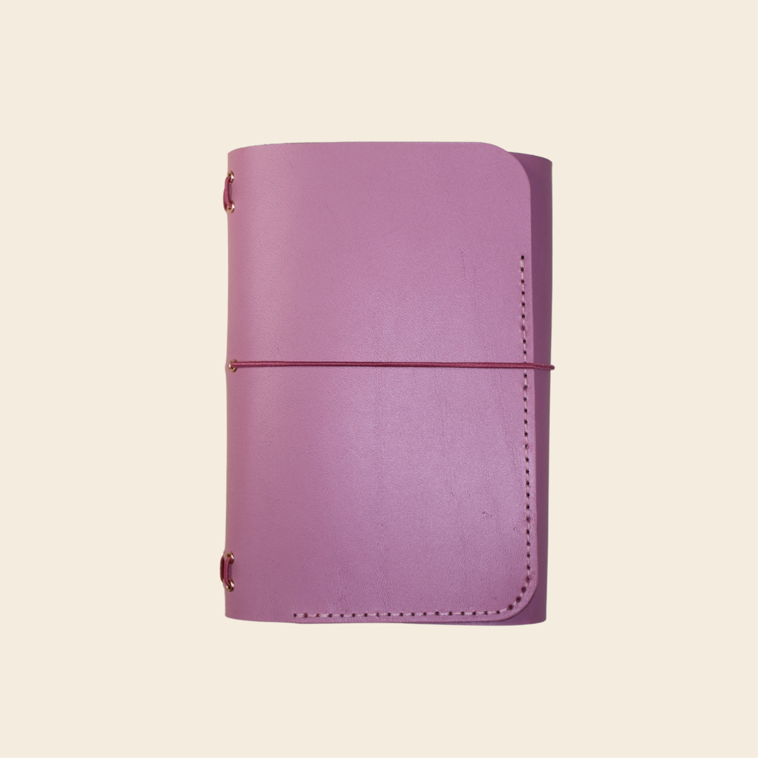 Mauve leather notebook on a beige background