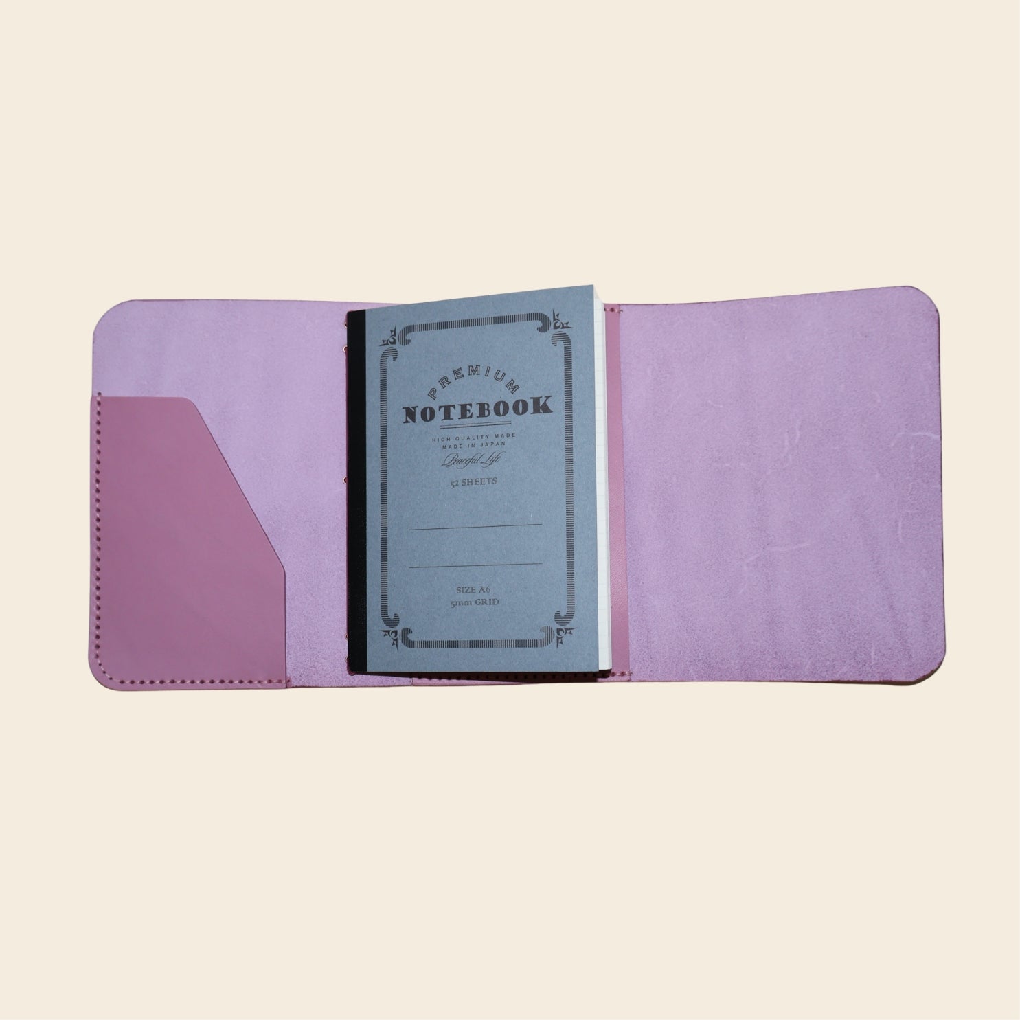 Mauve notebook with a notebook on a beige background