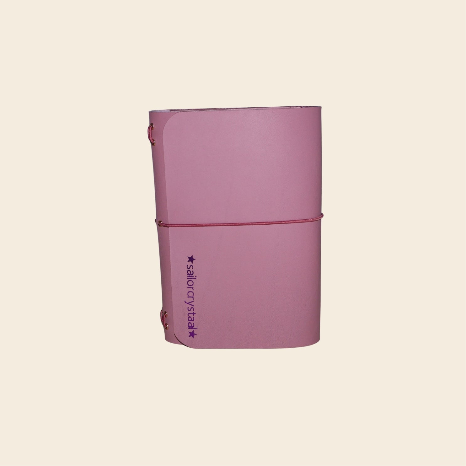 Mauve notebook with a visible brand logo on a beige background