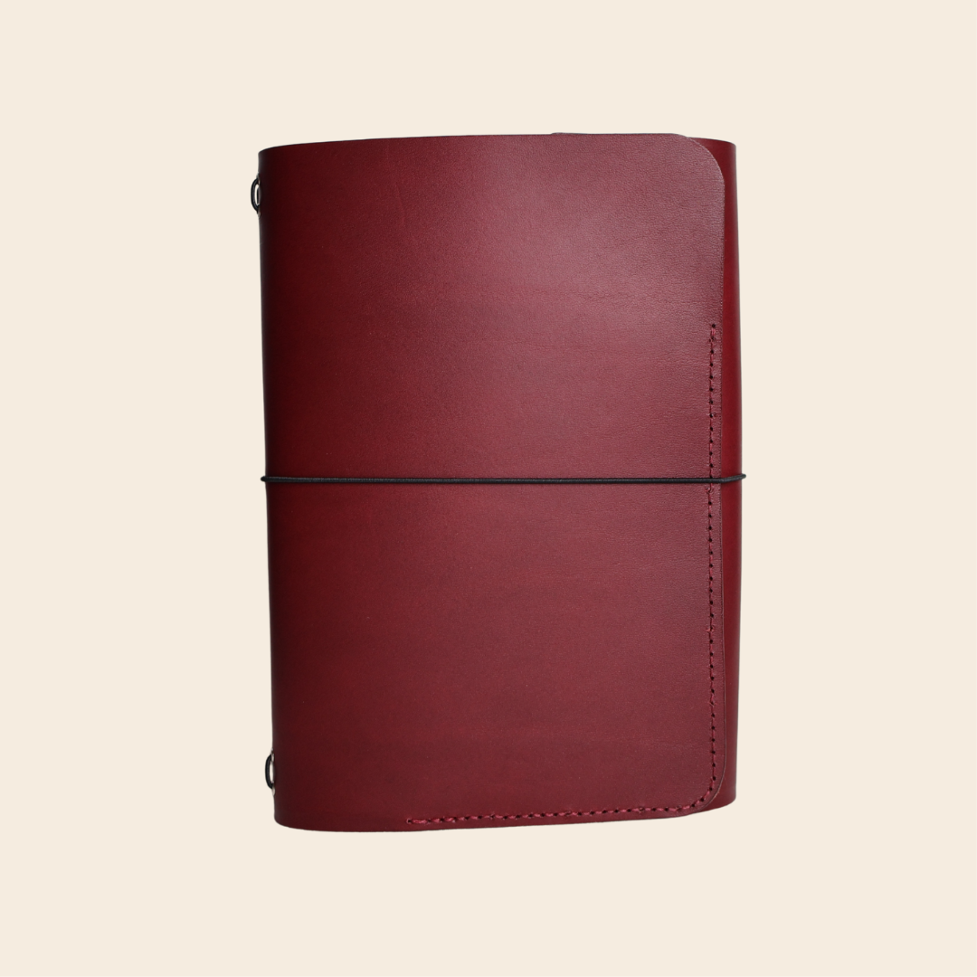 Maroon leather notebook on a beige background