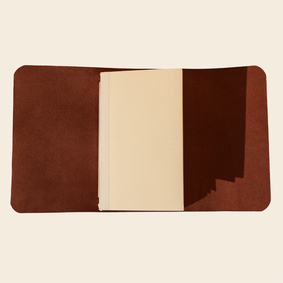 Brown leather wallet with beige interior on a white background