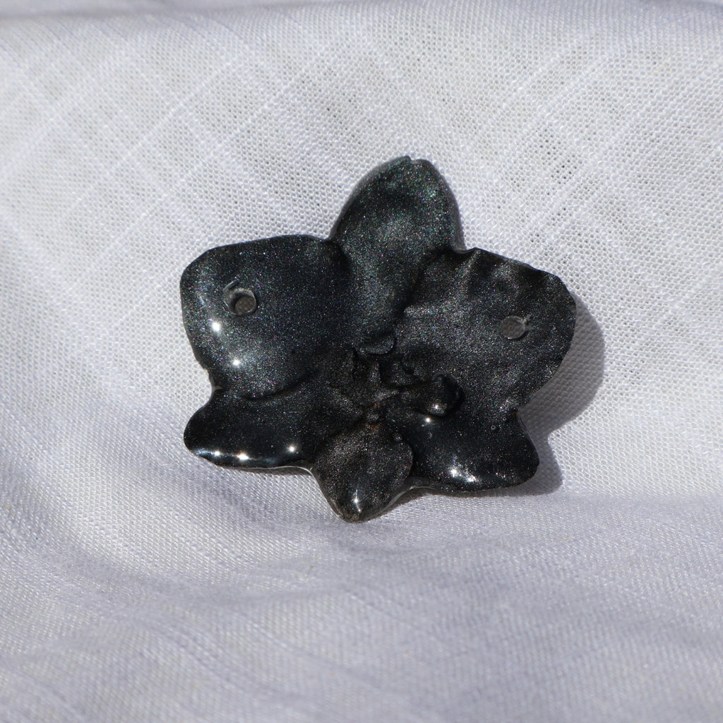 Black flower object on a white fabric background