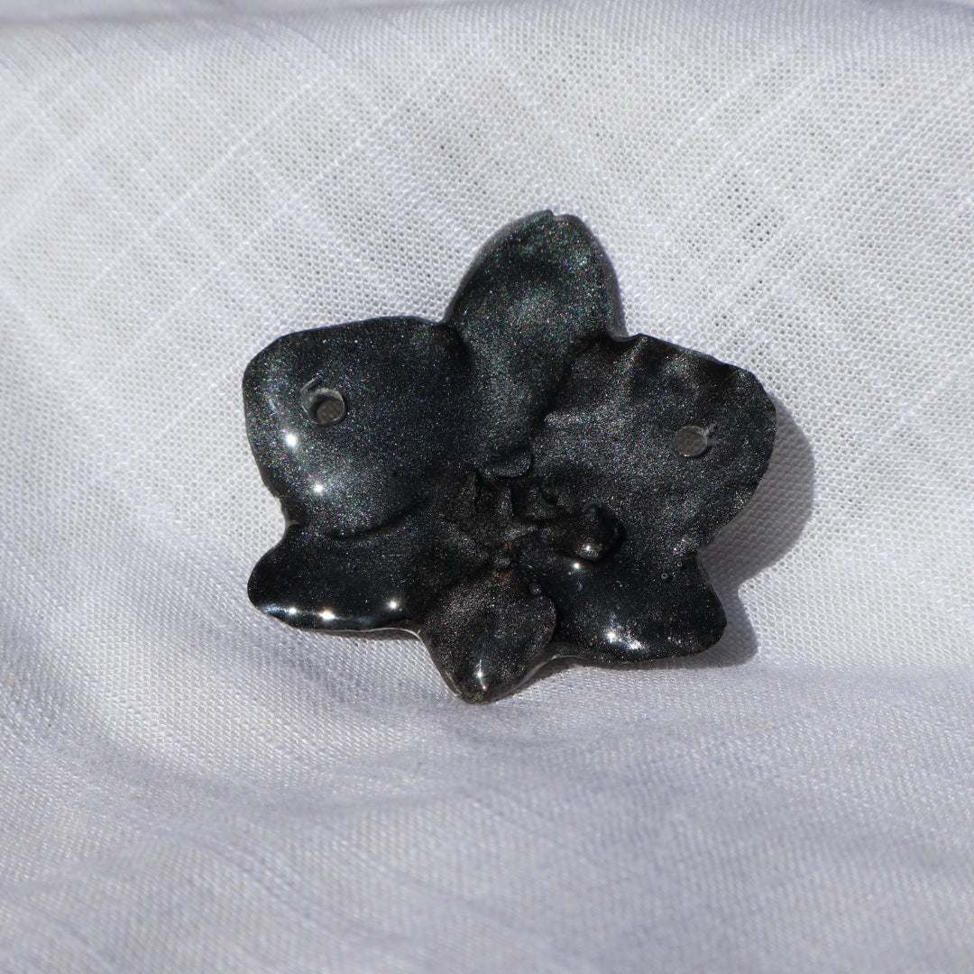 Black flower object on a white fabric background