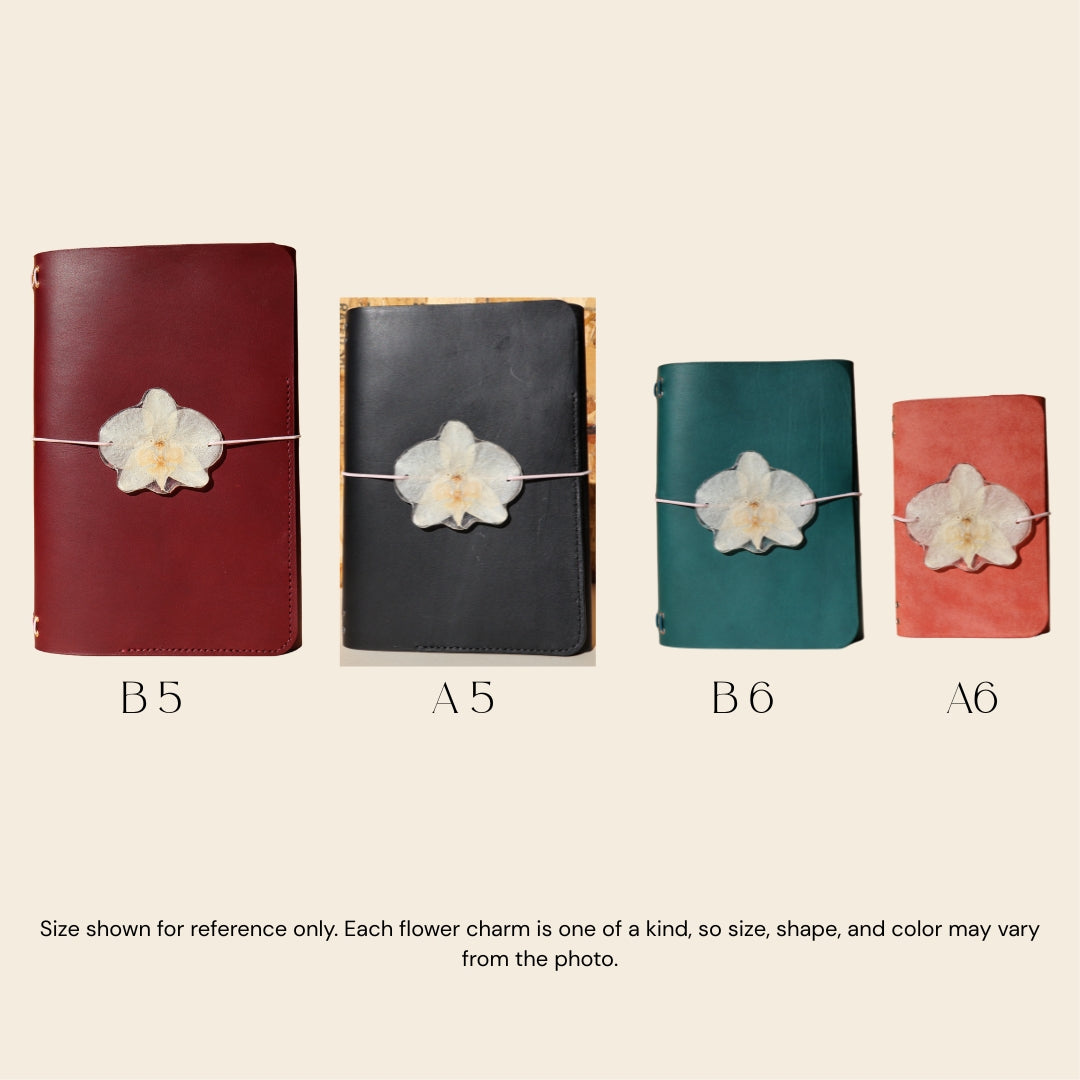 Four different sizes of notebooks with flower charms on a beige background